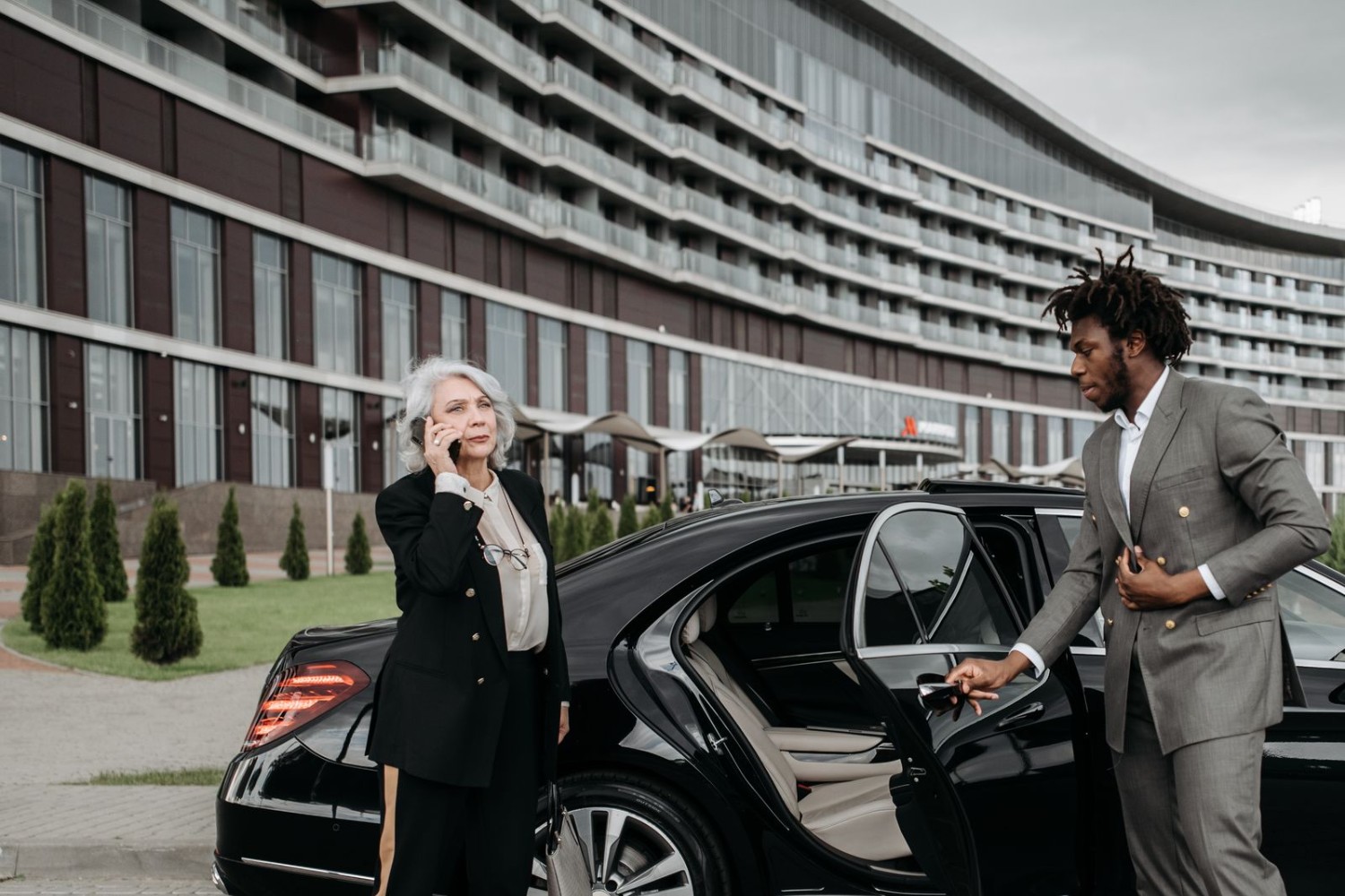 Professional chauffeur opening the car door for a business executive
