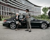 Chauffeur assisting a business executive out of a luxury car