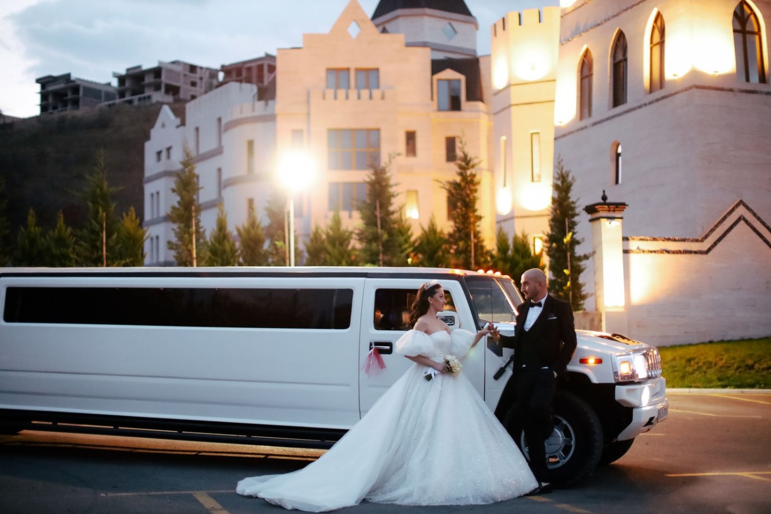Limousine parked outside an illuminated venue at night for a special event