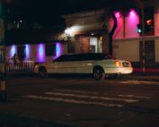 White stretch limousine on a city street at night
